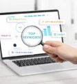 Magnifying glass over a laptop dashboard showing top keywords, a visual guide to keyword targeting and on page SEO