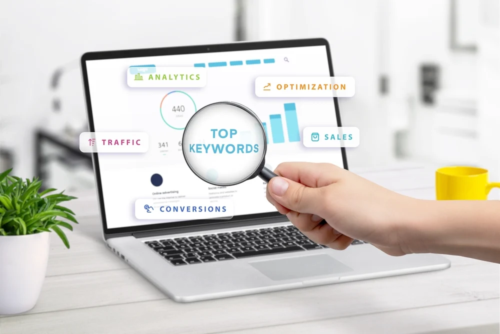 Magnifying glass over a laptop dashboard showing top keywords, a visual guide to keyword targeting and on page SEO